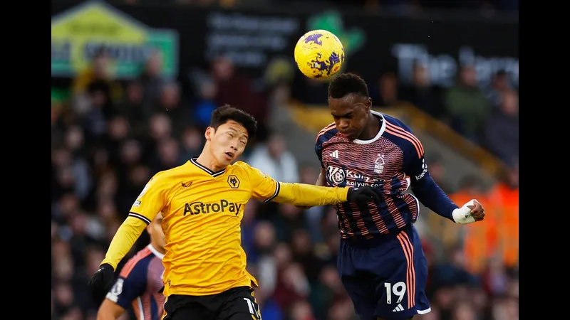 Cầu thủ Wolves với màu áo màu đỏ đang cố gắng cản phá một cầu thủ Nottingham Forest đang…